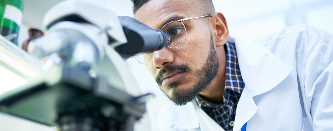 Scientist looking into microscope